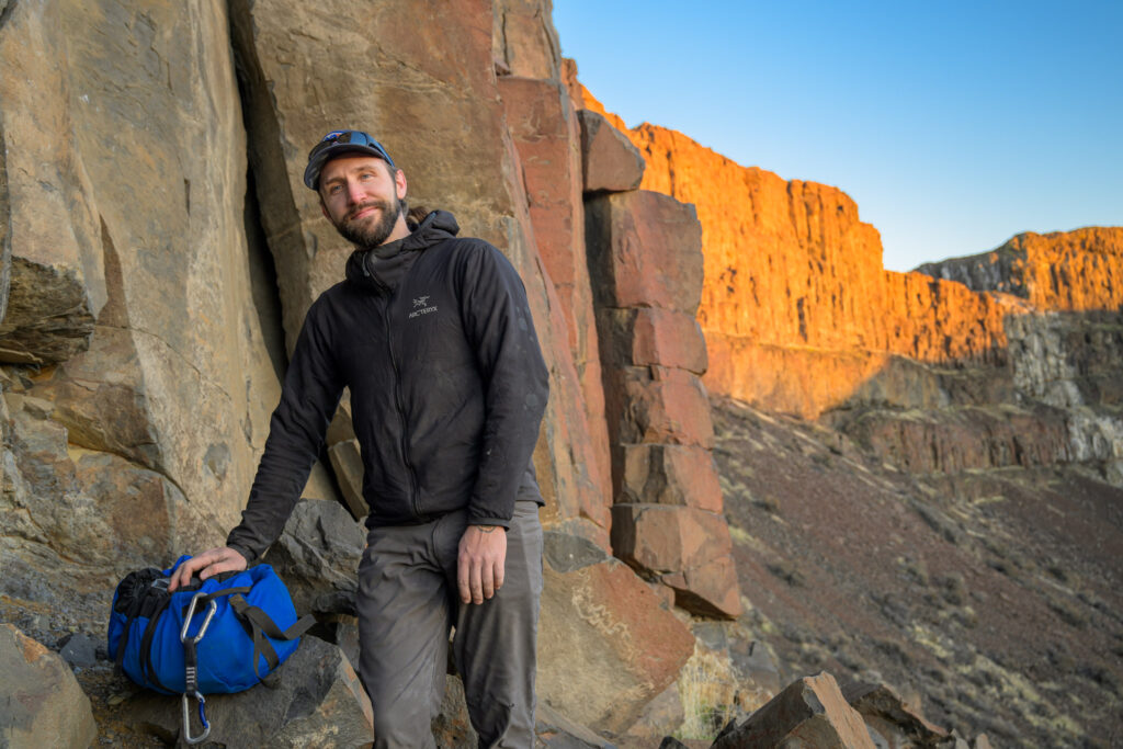 Portrait photograph of a climber in front of golden rocks.